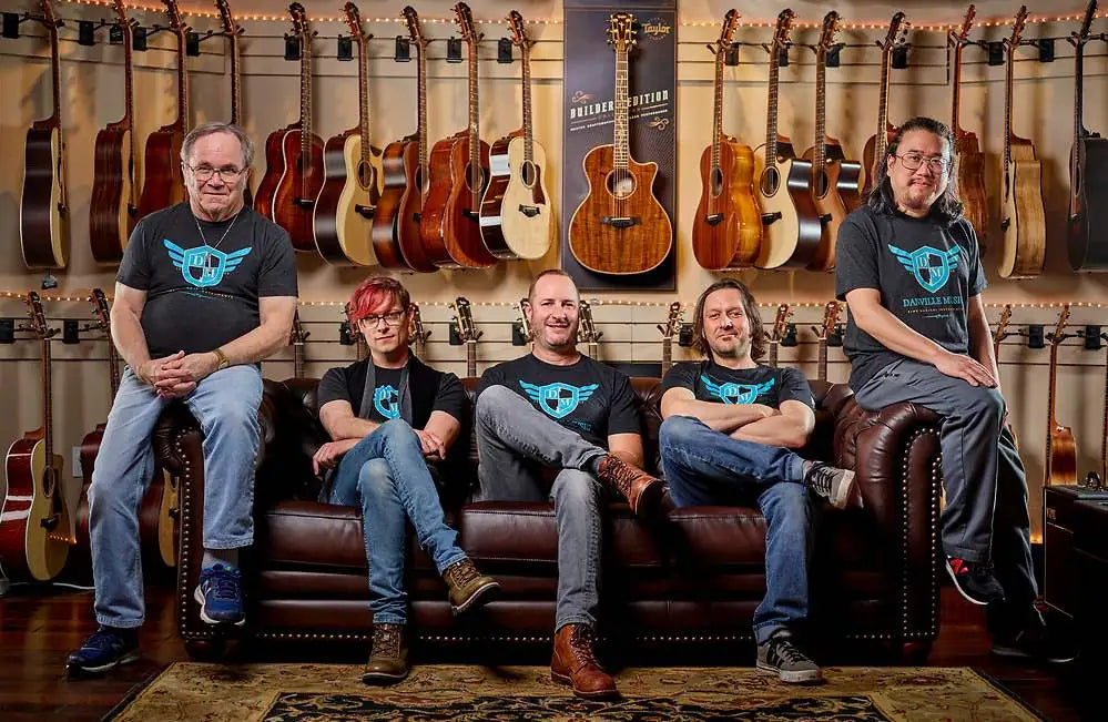 Danville Music guitar store staff seated in front of a wall of Taylor acoustic guitars in Danville, CA